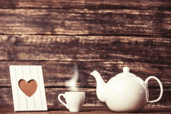 Teiera e tazza di caffè con cornice su tavolo in legno . — Foto Stock