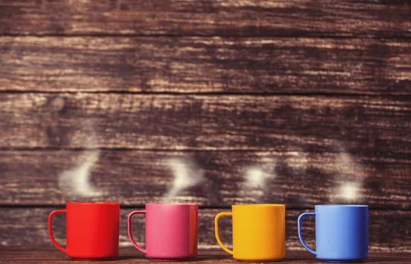 Cuatro tazas sobre mesa de madera . —  Fotos de Stock