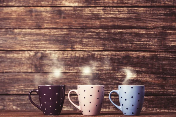 Three cups on coffee on wooden table. — Stock Photo, Image