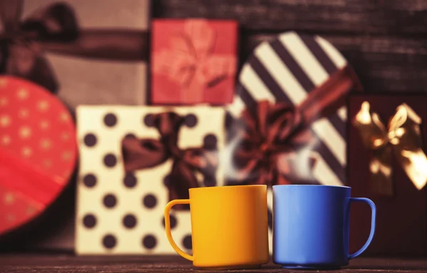 两杯咖啡和节日礼物在背景上. — 图库照片
