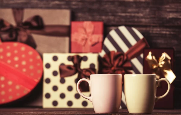Дві чашки кави і святкові подарунки на фоні . — стокове фото