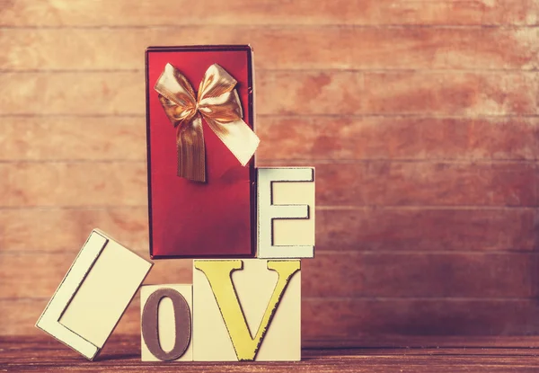 Little gift and word Love on wooden table. — Stock Photo, Image