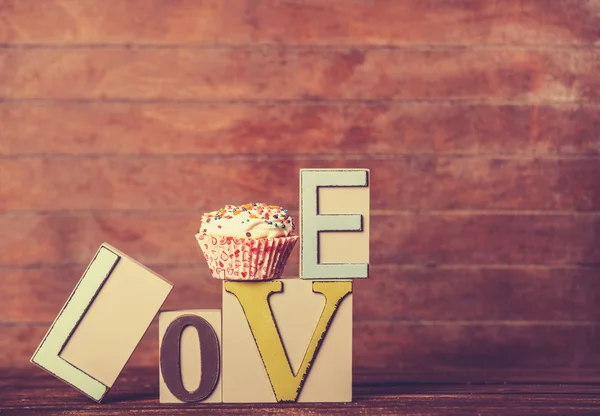 Cupcake und Wortliebe auf Holztisch. — Stockfoto