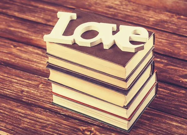 Λέξη αγάπη και βιβλία σχετικά με ξύλινο τραπέζι. — Φωτογραφία Αρχείου