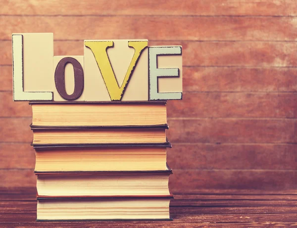 Słowa miłości i książek na drewnianym stole. — Zdjęcie stockowe