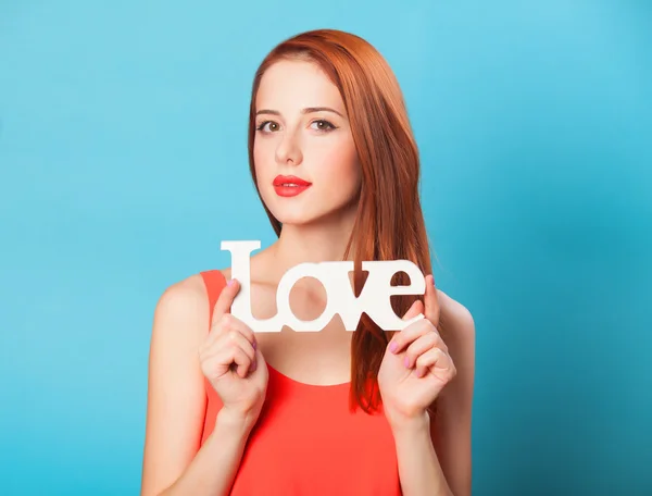 Mavi arka plan üzerinde kelime aşk ile mutlu Kızıl saçlı kadın. — Stok fotoğraf