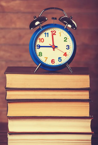 Relógio despertador e livros em mesa de madeira . — Fotografia de Stock