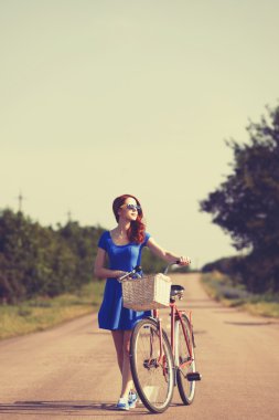 köy yolunda bisikletle olan Kızıl saçlı kız.