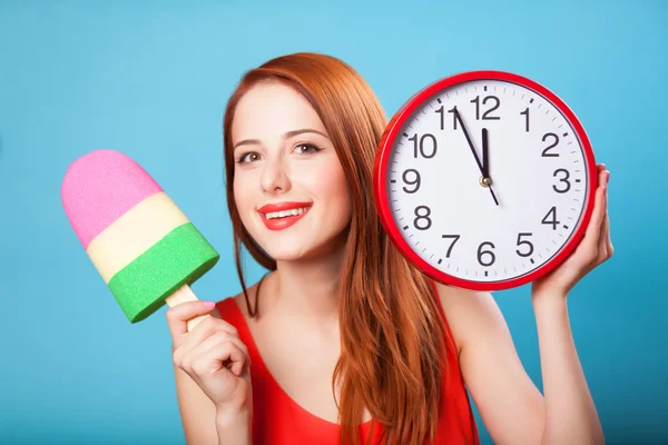 Redhead girl with toy ice cream and huge clock on blue backgroun — Stock Photo, Image