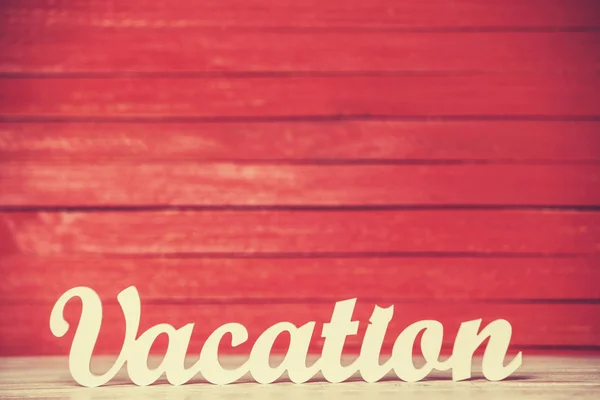 Wooden word Vacation on red background. — Stock Photo, Image