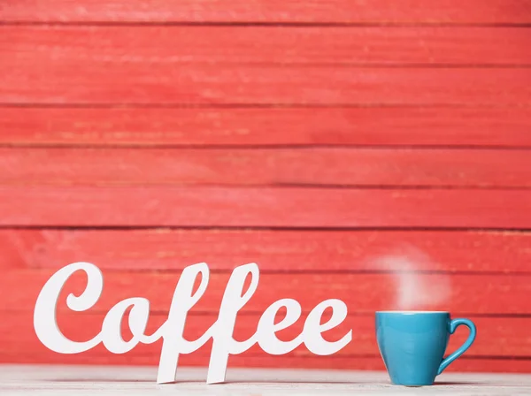 Абстрактное деревянное слово Кофе с чашкой на красном фоне . — стоковое фото