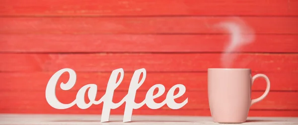Abstrakt trä ordet kaffe med kopp på röda trä bakgrund. — Stockfoto