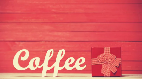 Абстрактное деревянное слово Кофе с подарком на фоне красного дерева . — стоковое фото