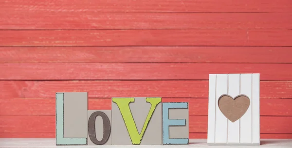 단어 사랑과 나무 테이블에 사진에 대 한 프레임. — 스톡 사진