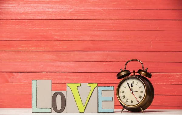 Reloj despertador y palabra de madera Love . — Foto de Stock