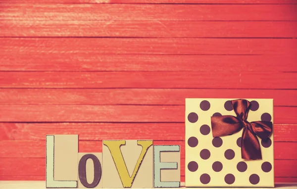 Маленький подарунок і слово Любов на дерев'яному столі . — стокове фото