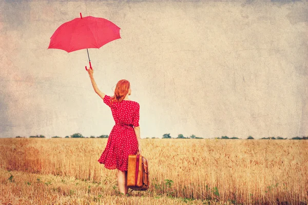 Ragazza rossa con ombrello e valigia all'aperto — Foto Stock