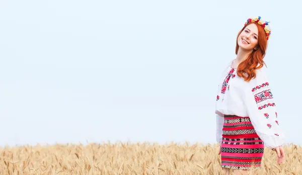 Menina ruiva em roupas ucranianas nacionais no campo de trigo . — Fotografia de Stock