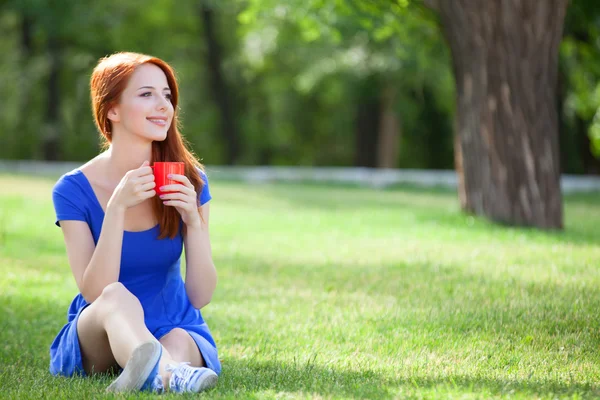 Rödhårig tjej med orange cup på utomhus — Stockfoto