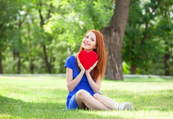 Rödhårig tjej med hjärta form i parken. — Stockfoto