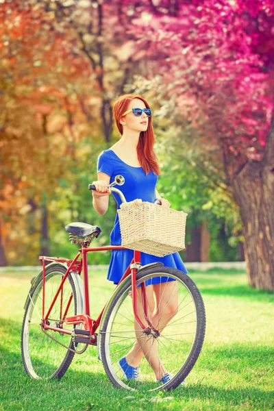 Redhead met fiets in het park. — Stockfoto