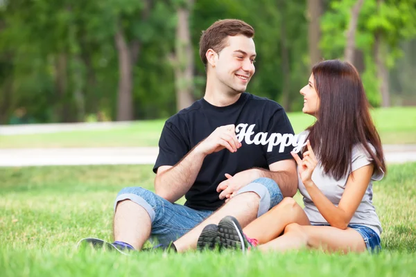 Couple adolescent avec mot Happy in the park . — Photo