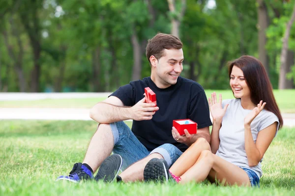 Teen couple with gift in the park. — Stock Photo, Image