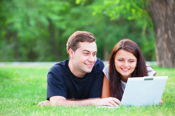 Teen par med anteckningsboken i parken — Stockfoto