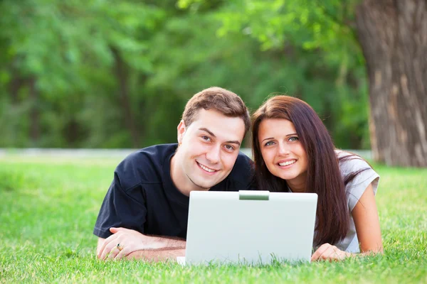 Couple adolescent avec ordinateur portable dans le parc — Photo