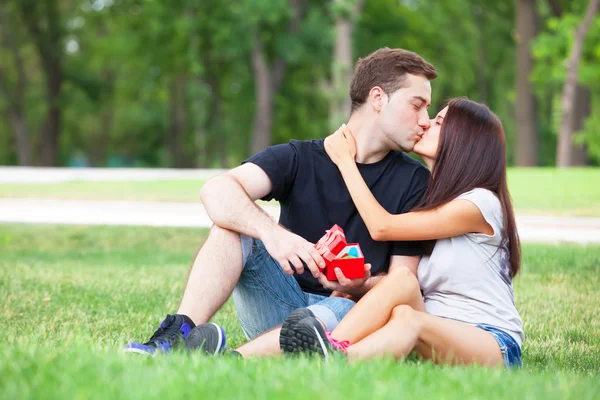 Teen couple with gift in the park. — Stock Photo, Image