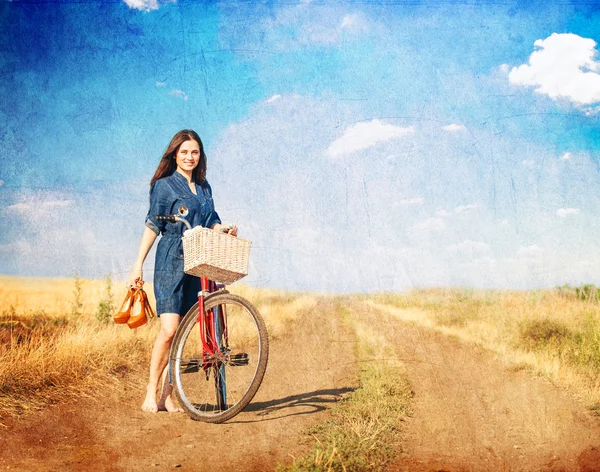 Brunette girl  with bycicle on countryside road. — Stock Photo, Image