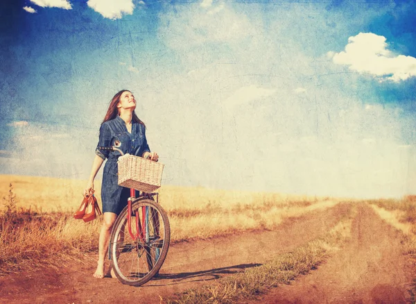 Brunette meisje met fiets platteland onderweg. — Stockfoto
