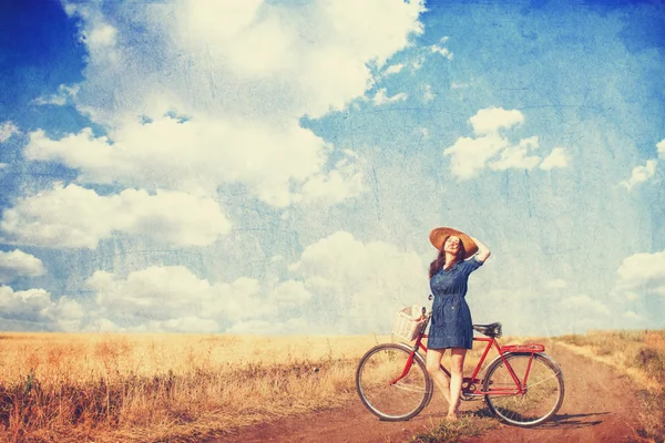 Bruna ragazza con bicicletta sulla strada di campagna . — Foto Stock