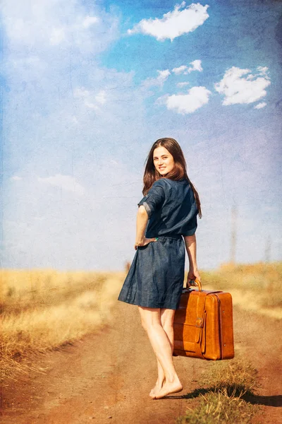 Brunette fille avec valise sur route de campagne . — Photo