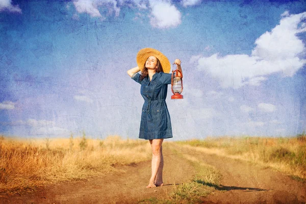 Chica con lámpara en el camino del lado del país . — Foto de Stock