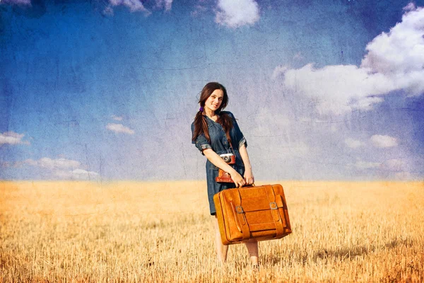 Brunette girl with suitcase on countryside. — Stock Photo, Image