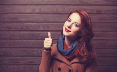 Kızıl saçlı kız ceket ahşap zemin üzerinde.