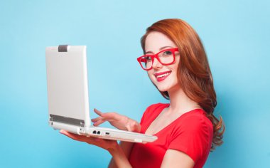 Kızıl saçlı kız ile mavi arka plan üstünde laptop.