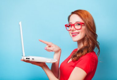 Kızıl saçlı kız ile mavi arka plan üstünde laptop.