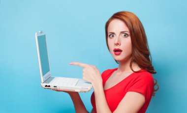 Kızıl saçlı kız ile mavi arka plan üstünde laptop.