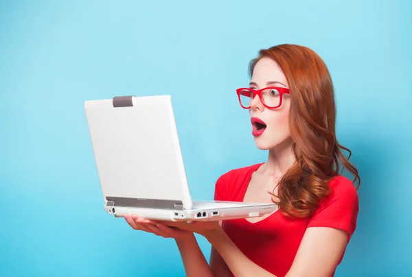 Menina ruiva com laptop no fundo azul . — Fotografia de Stock