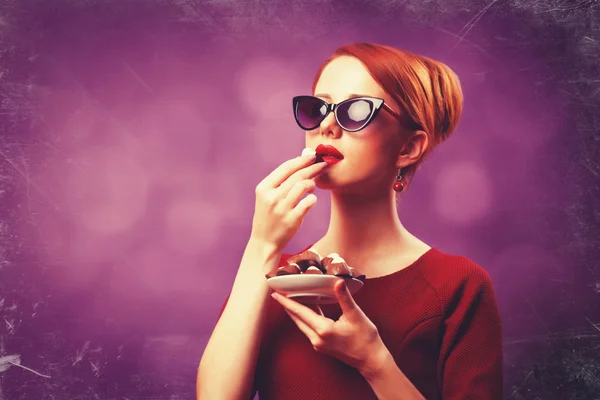 Mulheres ruivas com doces no fundo violeta . — Fotografia de Stock