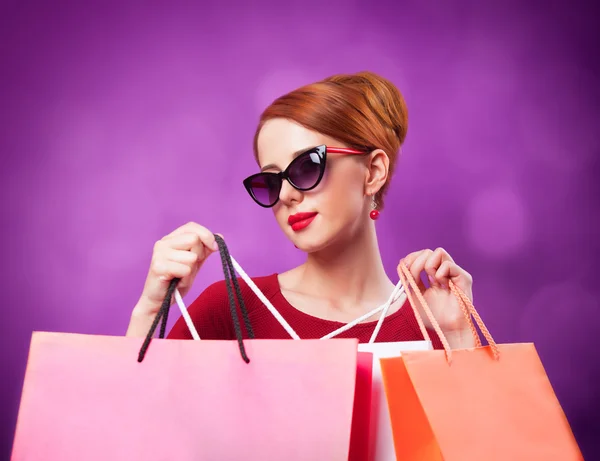 Pelirrojas con bolsas de compras sobre fondo morado . — Foto de Stock