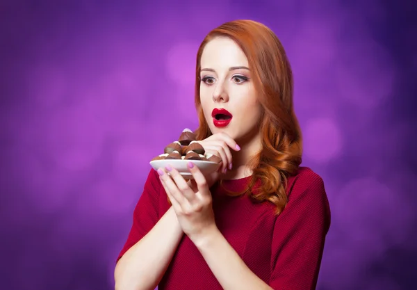 Pelirrojas con dulces sobre fondo violeta . —  Fotos de Stock