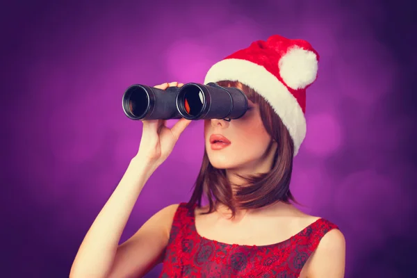 Chica morena con binocular y sombrero sobre fondo violeta . —  Fotos de Stock