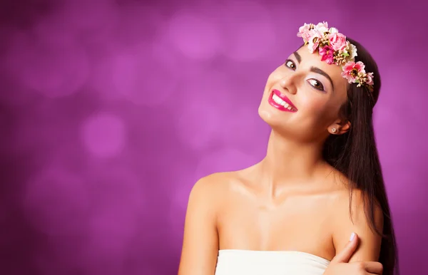 Brunette girl with wreath on violet background. Stock Image