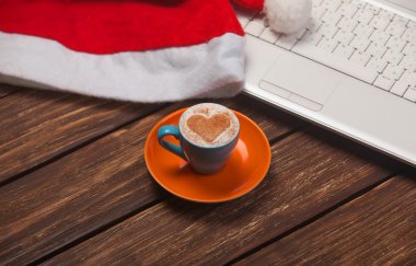 kahve kalp şekli, laptop ve Noel şapka ile.