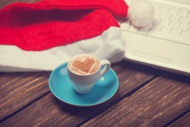 kahve kalp şekli, laptop ve Noel şapka ile.