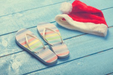 plaj terlikleri ve Noel şapka mavi ahşap üzerine