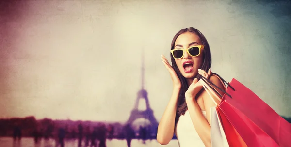 Chica morena con bolsas de compras en el fondo parisino . — Foto de Stock